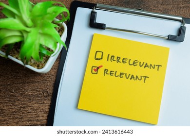 Concept of Irrelevant or Relevant write on sticky notes isolated on Wooden Table.