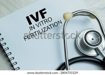 Concept of IVF - In Vitro Fertilization write on book isolated on Wooden Table. For embryo development and fertility treatment