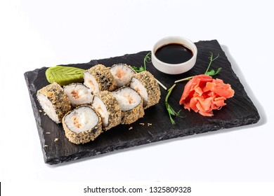 Concept Of Japanese Cuisine. Deep Fried Roll With Salmon And Mayonnaise In Panko Bread Crumbs. Near Soy Sauce, Ginger And Wasabi. Modern Serving Dishes In The Restaurant On A Black Slate Blackboard. 