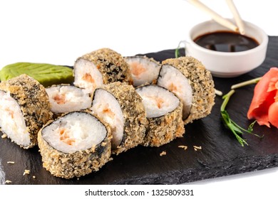 Concept Of Japanese Cuisine. Deep Fried Roll With Salmon And Mayonnaise In Panko Bread Crumbs. Near Soy Sauce, Ginger And Wasabi. Modern Serving Dishes In The Restaurant On A Black Slate Blackboard. 