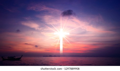 Concept of Jesus Christ: white cross on sunset sky background