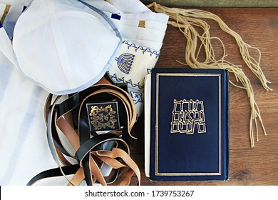 Concept Jewish prayer set: Hebrew Bible, Tefillin, Kippah (Kippa), Tsitsit (translated from Hebrew on the book Hebrew Bible: Torah, Neviim, Ketuvim or Acronyms - Tanakh; to tefillin: on the head)