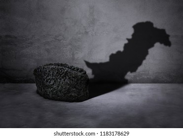 Concept of a karakul cap showing pakistan map in shadow for happy quaid e azam day on gray background.