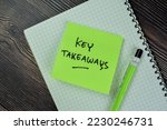 Concept of Key Takeaways write on sticky notes isolated on Wooden Table.