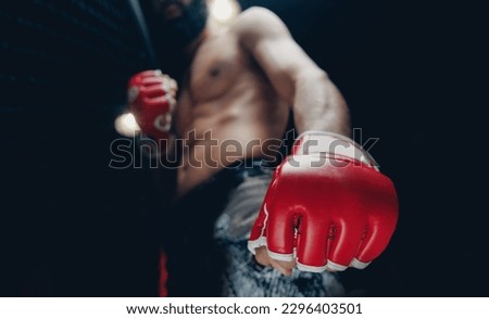Concept kickboxing sport banner, dark color. Closeup red Gloves for MMA of Boxers fighter in octagon.