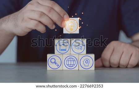 Concept of knowledge and management. Man put a wood block wood blocks with icon for learning on many wood block with icons education. Key to success of education.