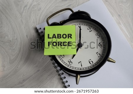 Concept of labor force write on sticky notes isolated on Wooden Table.