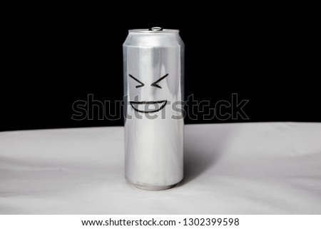 Concept of laugh man. grinning emoticon on aluminium can, Emoji with open mouth. On black background