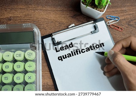 Concept of lead qualification write on clipboard isolated on Wooden Table.