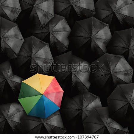 Concept of leader with with many blacks and a colorful umbrella