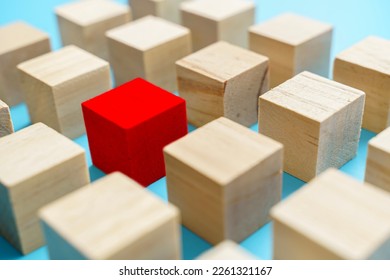 concept of leadership creative difference creativity Red blocks among brown blocks. Lifestyle. Business. Stand out from the crowd. Unique as leader red block opposite wooden.
