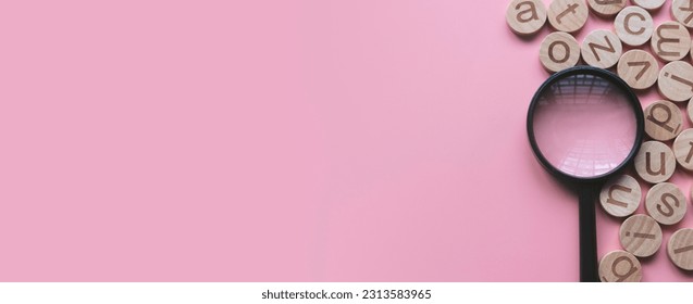 Concept of learning english, searching for word, and information. English alphabet letter and magnifying glass. Pink background with copy space. - Shutterstock ID 2313583965