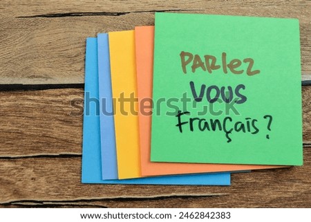 Concept of Learning language - German. Parlez Vous Francais it means Do you speak French written on sticky notes. German language isolated on Wooden Table.
