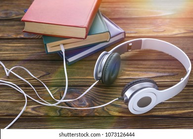 The concept is to listen to audiobooks. white headphones are connected to the book.