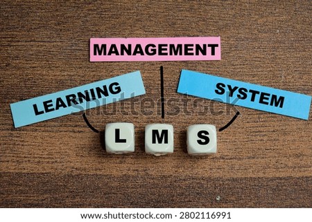 Concept of LMS - Learning Management System write on sticky notes isolated on Wooden Table.