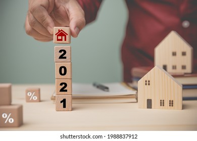 Concept loan buy house, banking, financial, accounting, insurance. Businessman holding wood block with icon red house on wood block,  setting goal future, 2021 must own a house. - Shutterstock ID 1988837912