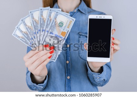 Concept of loan, touchscreen, touch screen, interface, gift people person, fan of bill, jeans shirt, online  store, transfer. Close up portrait of lady with usa cash and smartphone isolated background