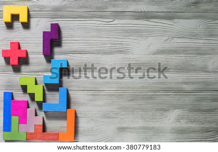The concept of logical thinking. Geometric shapes on a wooden background. 
Tetris toy wooden blocks.