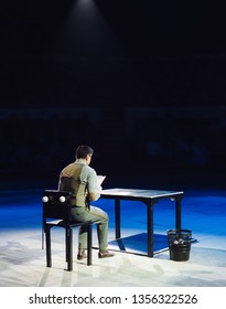 Concept. A Lone Office Worker Sits In A Dark Room