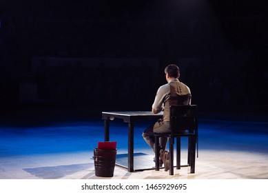 Concept. A Lone Office Worker Sits In A Dark Room.