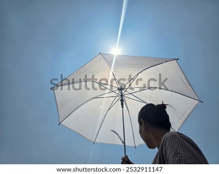 concept of long drought causing heat wave and global warming in asia, woman outdoors with umbrella protecting herself from hot sun rays and heat wave. hot temperatures in Asia.