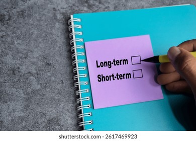Concept of Long-term or short-term write on sticky notes isolated on Wooden Table.