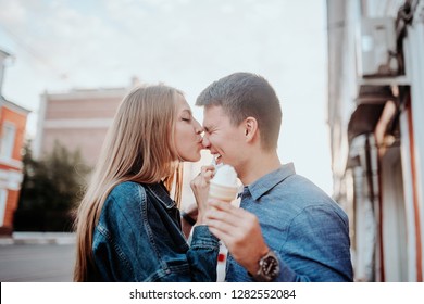 Concept of love relationships man and woman. Lovely couple walking in the big city, hugging, kissing and enjoying each other. eat ice cream and have fun side view - Powered by Shutterstock