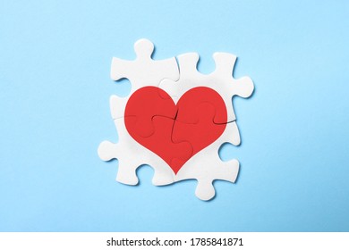 Concept love  White puzzle pieces and illustration heart light blue background  top view