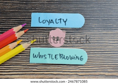 Concept of Loyalty or Whistleblowing write on sticky notes isolated on Wooden Table.