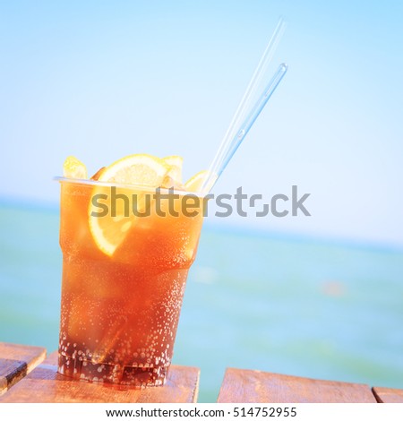 Concept of luxury vacation. Cuba Libre cocktail on the pier. Long island ice tea cocktail on the pier. Tropical vacation background. Right side angle. Clear blue sky. Square