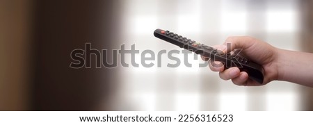 concept - man with his remote control watching tv in his living room