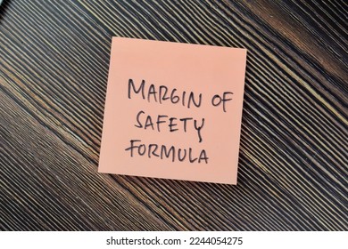Concept of Margin of Safety Formula write on sticky notes isolated on Wooden Table.