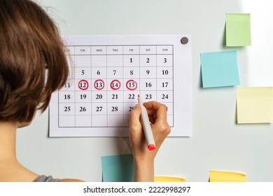 The concept of the menstrual cycle, ovulation period. The woman marks the days on the calendar.