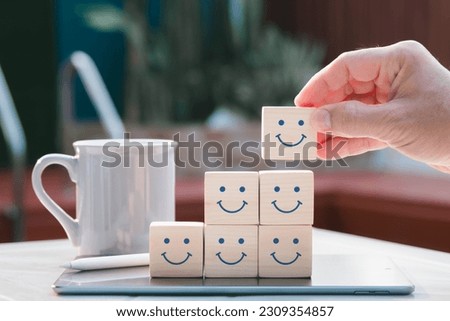Concept of mental and emotional well-being; a happy face is displayed on the face of a wooden block cube to represent a good outlook.