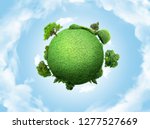 concept miniature globe showing the environment with trees and grass on cloudy sky background