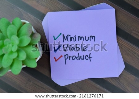 Concept of Minimum Viable Product write on sticky notes isolated on Wooden Table.