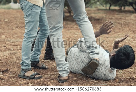 Concept of mob lynching - Group of people bullying, kicking a man - Close up of young adult males hitting a person on ground. Stock foto © 