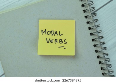 Concept of Modal Verbs write on sticky notes isolated on Wooden Table.