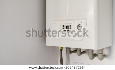 Concept of modern appliance. Side view of new white water heater at the kitchen closet, copy space. Home gas-fired boiler. Installation of household heating equipment in the house