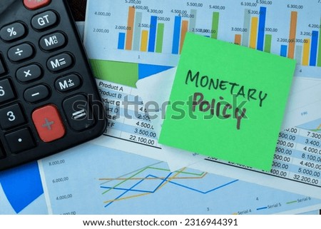 Concept of Monetary Policy write on sticky notes isolated on Wooden Table.