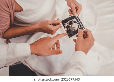 Concept Motherhood and Pregnant, Prenatal care and pregnancy. Male doctor showing ultrasound picture to pregnant woman with pregnant woman in hospital.