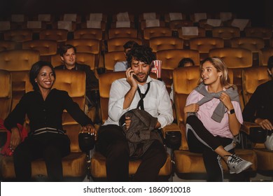 Concept Movie Theater Etiquette : Group Of Men And Women Talking On The Phone And Making Laughter Loudly Annoying And Without Etiquette In The Cinema, Disturbing Others.

