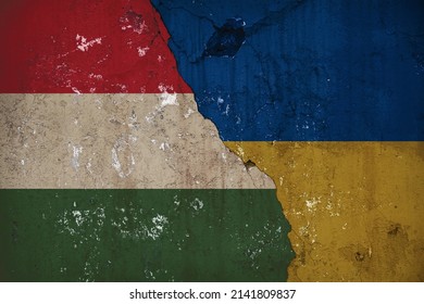 The concept of mutual assistance between Ukraine and the countries of the European Union. Flags of Ukraine and Hungary on an old worn wall.