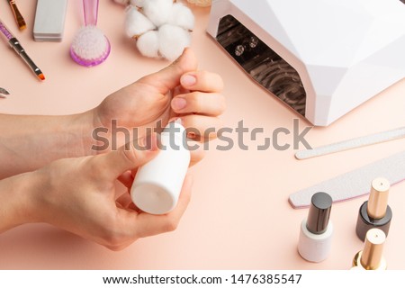 The concept of nail art. Woman gives herself a manicure on a white table, wow behind the nails, close-up. care for the nails