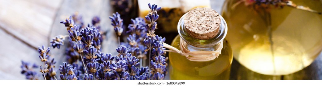 Concept of natural organic oil in cosmetology. Moisturizing skin care and aromatherapy. Gentle body treatment. Handmade soap. Atmosphere of harmony relax. Wooden background, lavender flower. Banner
