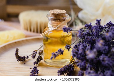 Concept of natural organic oil in cosmetology. Moisturizing skin care and aromatherapy. Gentle body treatment. Atmosphere of harmony relax. Wooden background, lavender flower, brush, soap. Close up