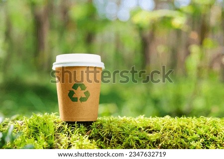 The concept of nature conservation and zero waste. Eco-friendly paper cup with a recycling sign on the background of wildlife [[stock_photo]] © 