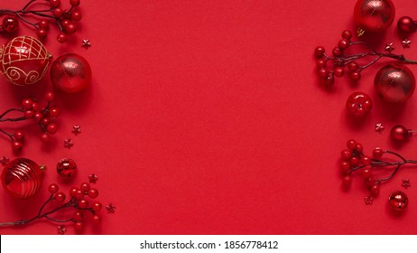Concept for New Year and Christmas banner.Christmas decor, red balls, berries and stars on a red background, top view, flat lay, copy space.Christmas card with place for text, lettering.