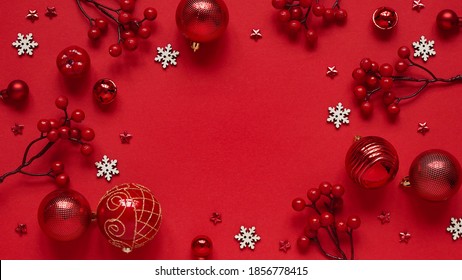 Concept for New Year and Christmas banner.Christmas decor, red balls,berries,stars and white snowflakes on a red background,top view,flat lay,copy space.Christmas card with place for text, lettering.