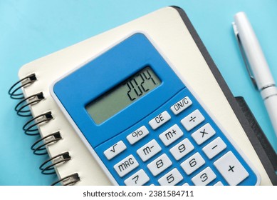 Concept of new year finance, inflation, recession, tax, budget and cost of living. Financial reminder of fiscal year 2024. 2024 on calculator screen.	